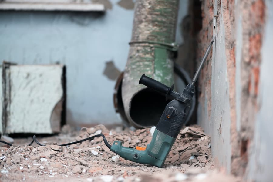 Hammer drill resting on wall before being used to drill holes