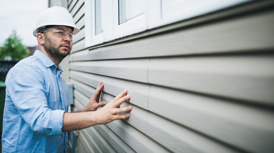 Building inspector at work inspecting windows of residential building