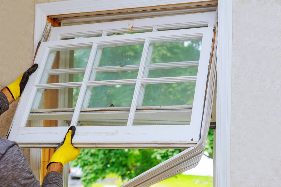 Man removing an old window